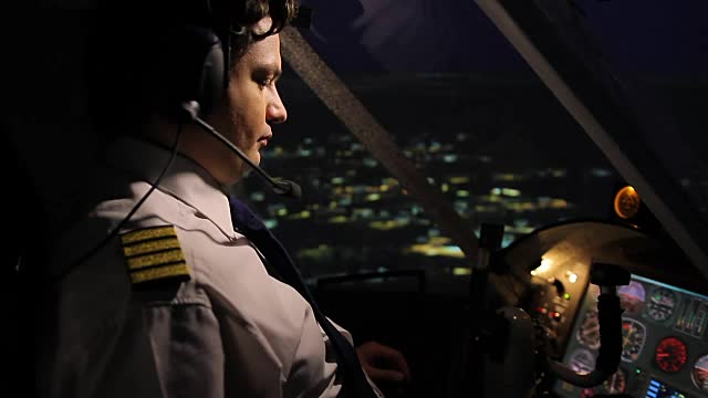 夜间在城市上空驾驶飞机的专业机组指挥官视频素材