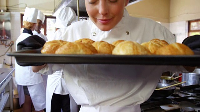 女厨师拿着面包在冷却盘里视频素材