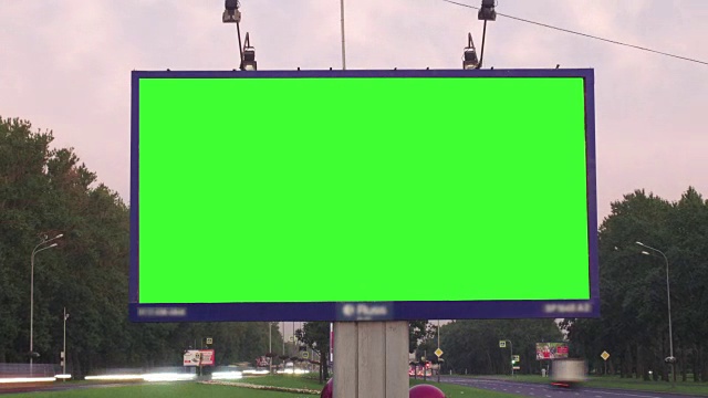 繁忙街道上的一个绿屏广告牌视频素材