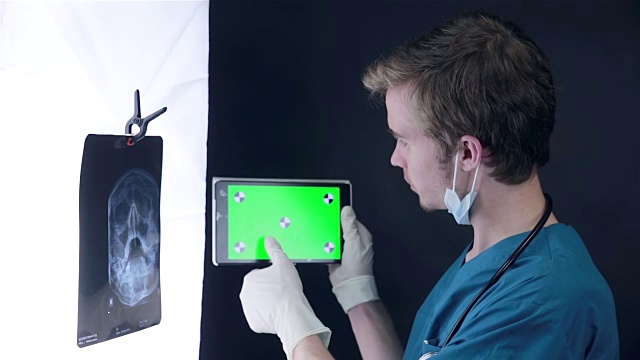 专业医生工作与x射线扫描和平板电脑与绿色屏幕视频素材