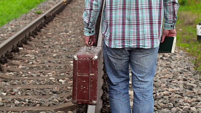 在铁路上带着书和手提箱的人视频下载