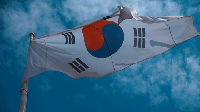 韩国国旗在旗杆上迎风飘扬，映衬着湛蓝的天空视频下载