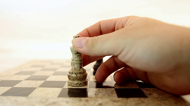 一个黑棋国王站在棋盘中间一个人把一个白棋国王放在黑棋国王前面视频下载