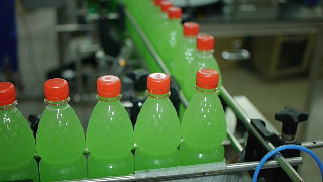 瓶子沿着生产线移动，柠檬水、苏打水、矿泉水被灌装和包装视频素材