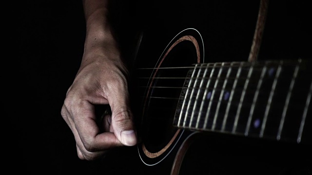 超级慢动作的男人用黑暗的音调弹奏吉他视频素材