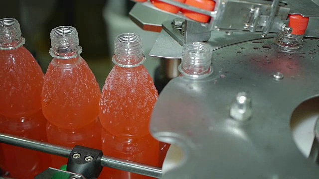 自动旋盖一瓶苏打矿泉水，柠檬水自动输送流水线视频素材