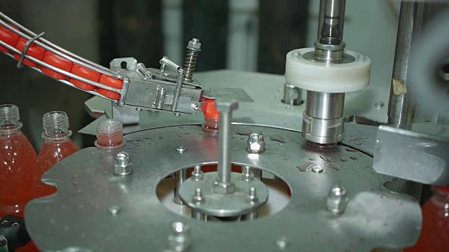 生产线上的螺旋输送机盖上一瓶柠檬水苏打矿泉水视频素材