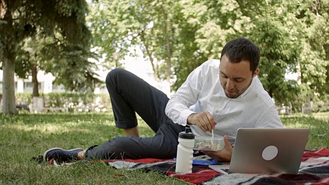 有魅力的男人在公园吃午餐，对着镜头说些什么视频下载