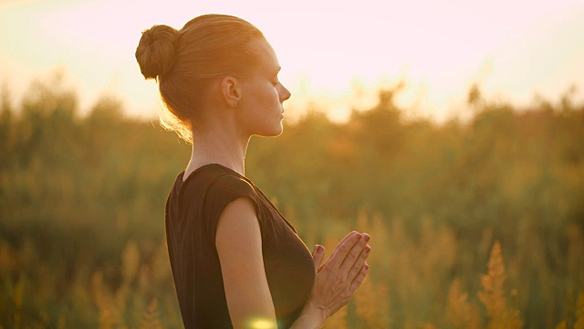 美丽年轻健康的女人做瑜伽运动在日落视频下载