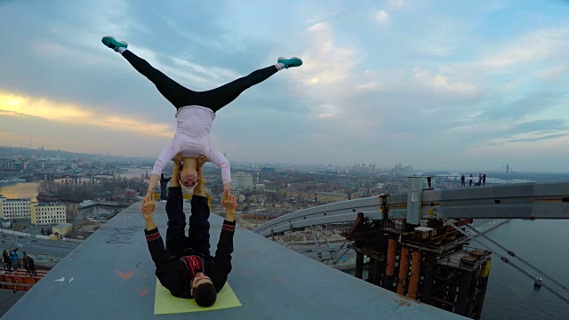 专业运动员在高桥顶上的危险特技，跨越瑜伽姿势视频下载