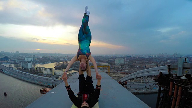 男人和女人在桥上练习杂技瑜伽，危险的运动视频下载