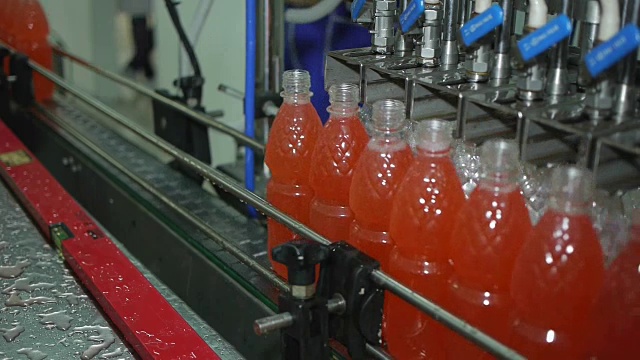 机器倒柠檬汽水瓶，并沿着传送带移动在生产视频素材