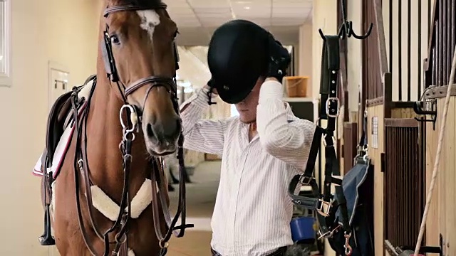 年轻人在马旁边戴上了头盔视频下载