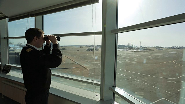 空中交通管制员正在用双筒望远镜观察机场的距离视频素材