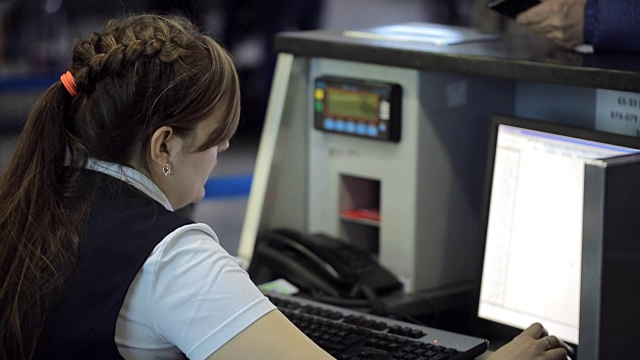 在机场，一位女士正在接待处用电脑工作视频素材