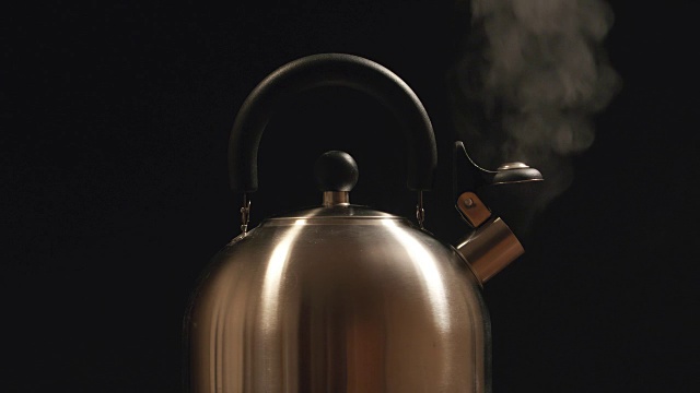 钢壶里的蒸汽。黑色背景视频下载