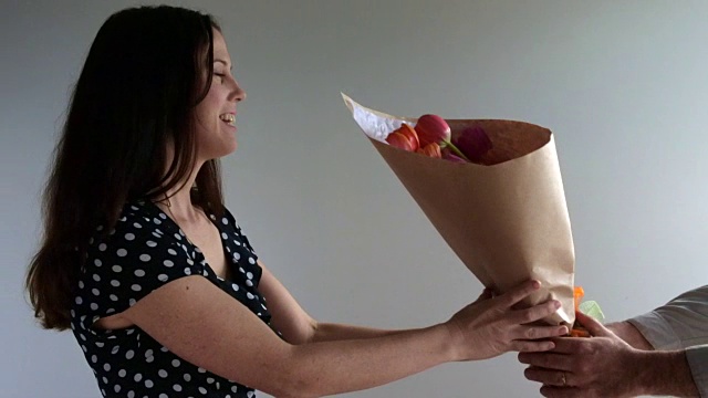 惊讶的女人收到了来自她的爱人的郁金香花视频素材