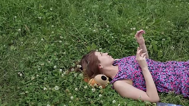 那个女孩躺在草地上，手里拿着一朵花视频素材