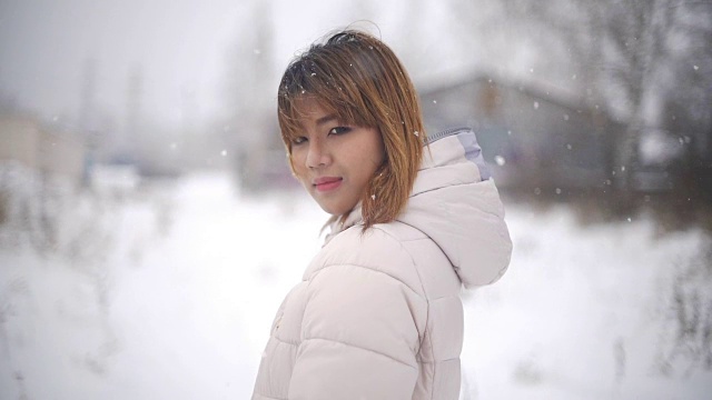 年轻的亚洲女人在下雪。Slowmotion视频下载