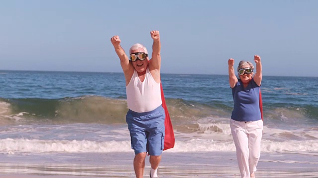 一对老年情侣在海滩上做超级英雄视频下载