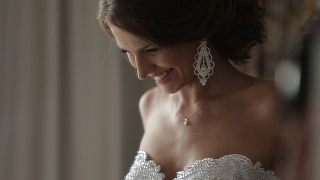 优雅的黑发新娘与美丽的耳环和钻石礼服准备结婚的日子视频素材