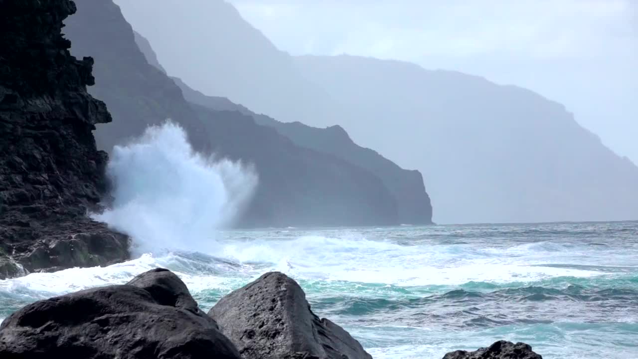 慢镜头:强大的海浪溅入雄伟的波涛汹涌的海洋悬崖视频素材