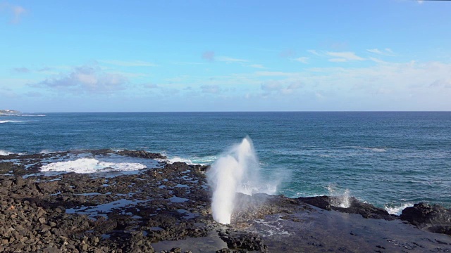 慢动作:汹涌的海浪溅过岩石海岸的气孔视频素材