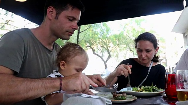 家人一起在外面吃饭。夫妇与婴儿蹒跚学步视频素材