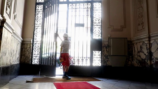 男孩拿着门。孩子抱着欧式门。梦幻的场景看视频素材