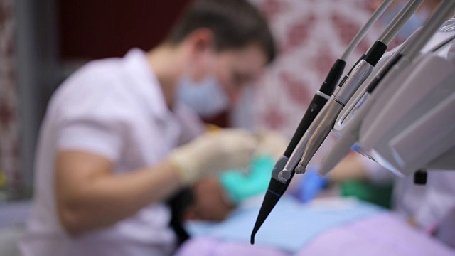 牙科单位的工具，背景工人和牙医躺病人视频下载