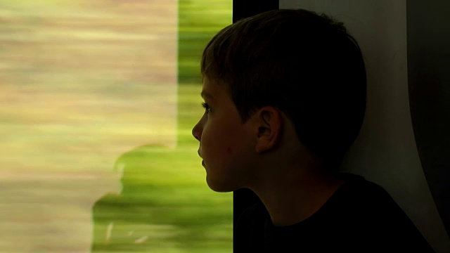 小男孩乘火车旅行。孩子望着火车窗外。孩子在火车窗外观察视频素材