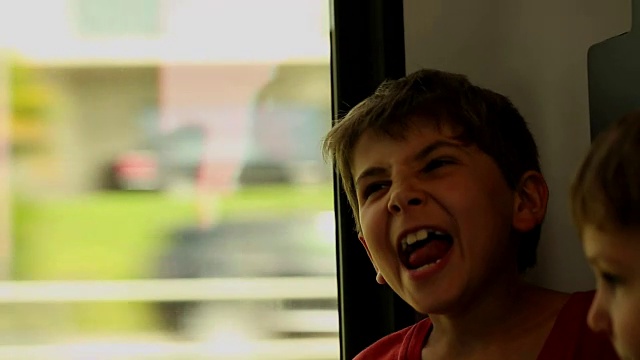 小男孩在乘火车旅行时叹了口气。孩子在火车上叹气视频素材
