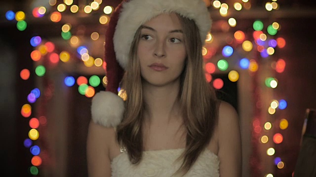 一个悲伤的年轻女人戴着圣诞帽，看起来很无聊视频下载