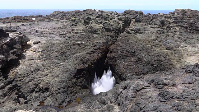 慢镜头特写:海水溅过粗糙的岩石气孔视频素材