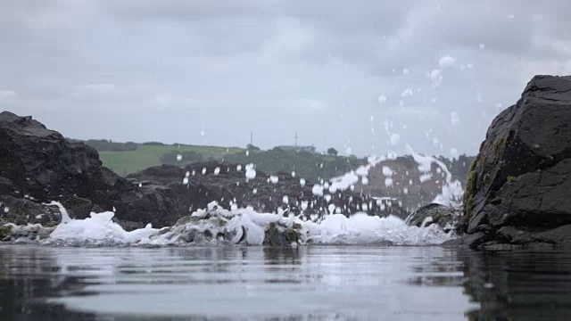 近景:海浪猛烈地冲击着粗糙的岩石墙视频素材