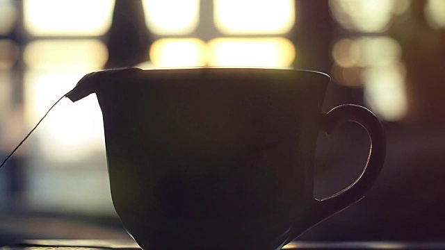 茶包放在阳光上慢动作的茶杯里。1920 x1080。高清视频下载