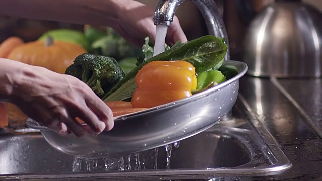 洗新鲜蔬菜的场景。花椰菜、胡椒和胡萝卜。在水龙头下。视频下载