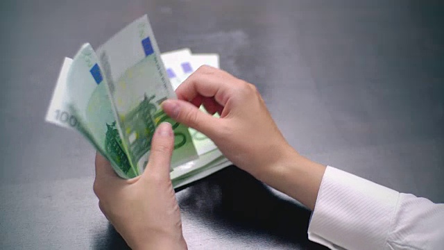 一个女人数着100欧元钞票视频素材