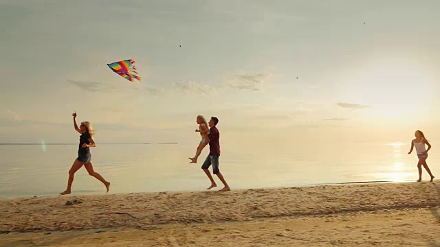 妈妈和孩子们玩风筝。孩子们在海滩上无忧无虑地奔跑。快乐的童年视频素材