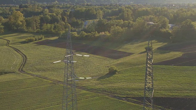 天线:草地上的高压电线和电力钢塔视频素材