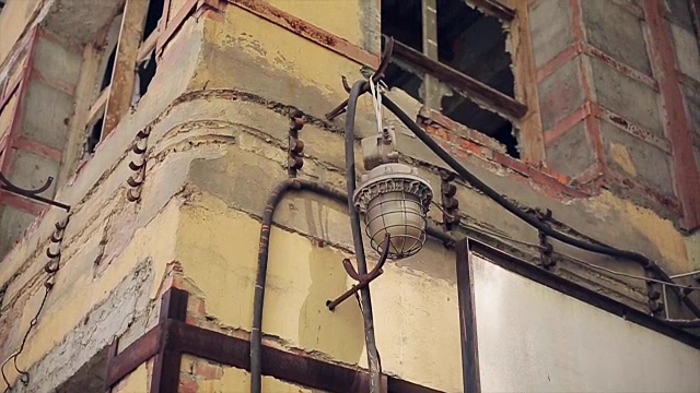 窗户没有玻璃的废弃建筑墙上的旧手电筒。破旧的墙壁视频素材