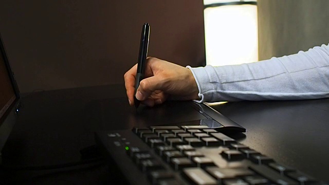 平板电脑23。近距离的一个图形设计师的手使用电子笔和键盘的工作。左视图视频下载
