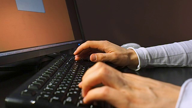 键盘25。男性的手用鼠标和键盘在液晶显示器上打字文件的特写视频素材