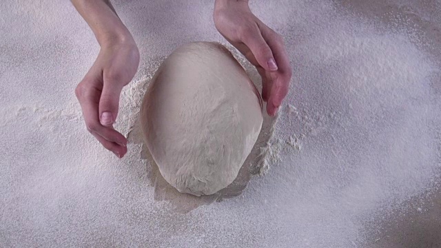 女人们的手在满是面粉的木桌上揉面团视频下载
