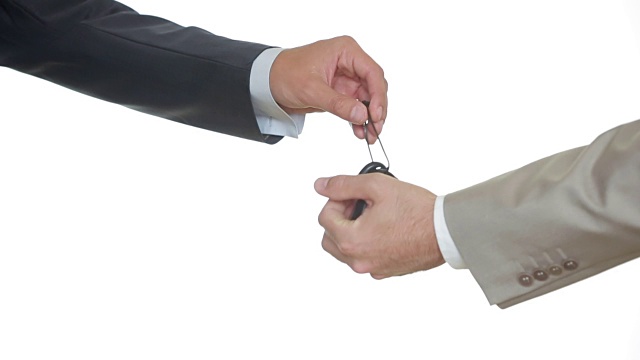 男性手拿着一把车钥匙并把它交给另一个人。握手视频下载