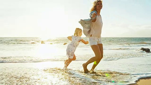 妈妈和女儿在海滩上玩耍视频素材