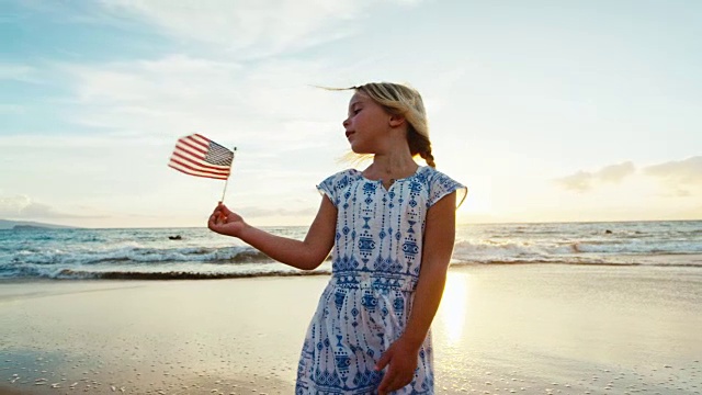 小女孩在海滩上玩美国国旗视频素材