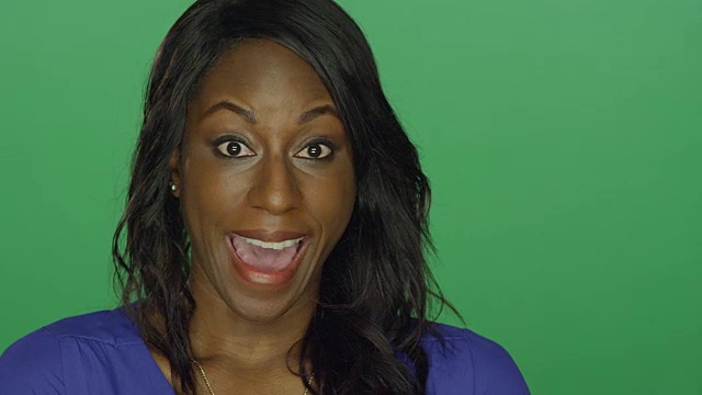 美丽的非洲裔美国妇女微笑和做傻傻的脸，在一个绿色屏幕的工作室背景视频下载