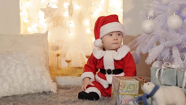 小男孩穿着圣诞老人拿着圣诞礼物视频下载
