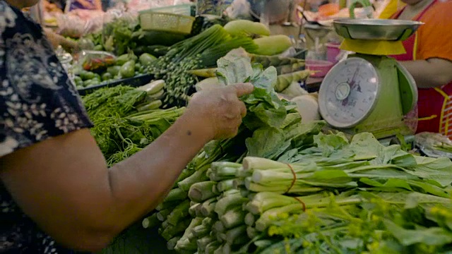 在市场上买新鲜蔬菜的女人。视频素材